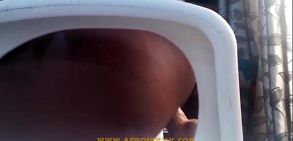  African with mini skirt fucks herself with a toy on the chair